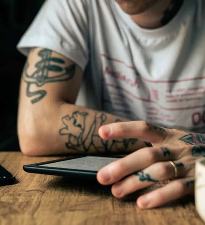 Person with tattoos using a tablet